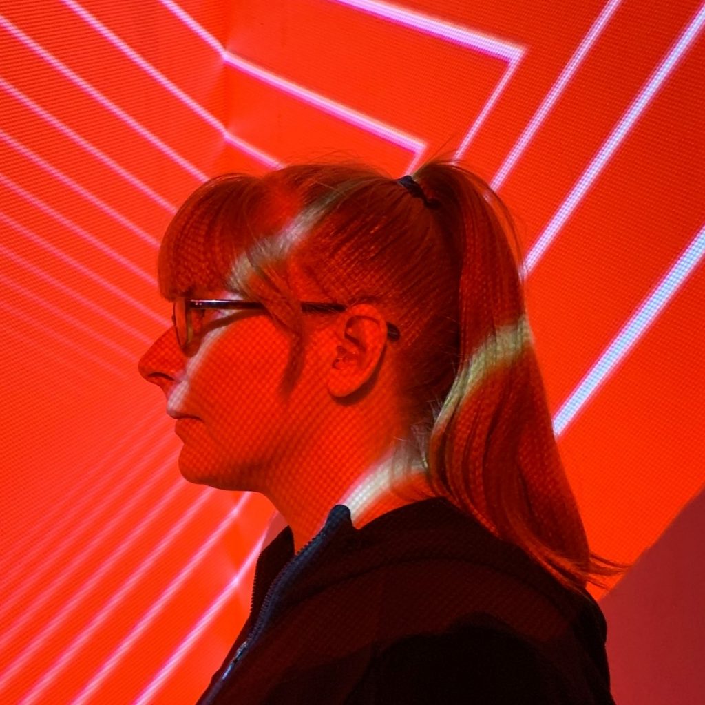 Detroit electronic musician Erika in profile under red projected light