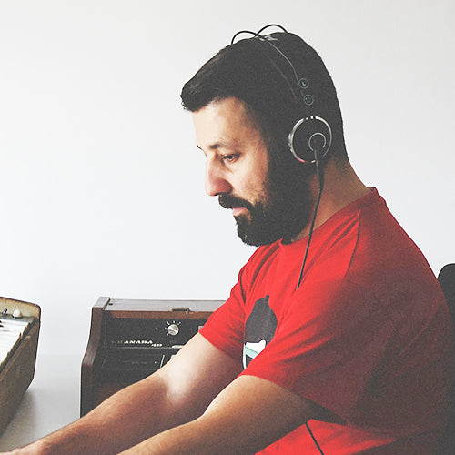 John Valasis at work in headphones, photographed for Soundiron.