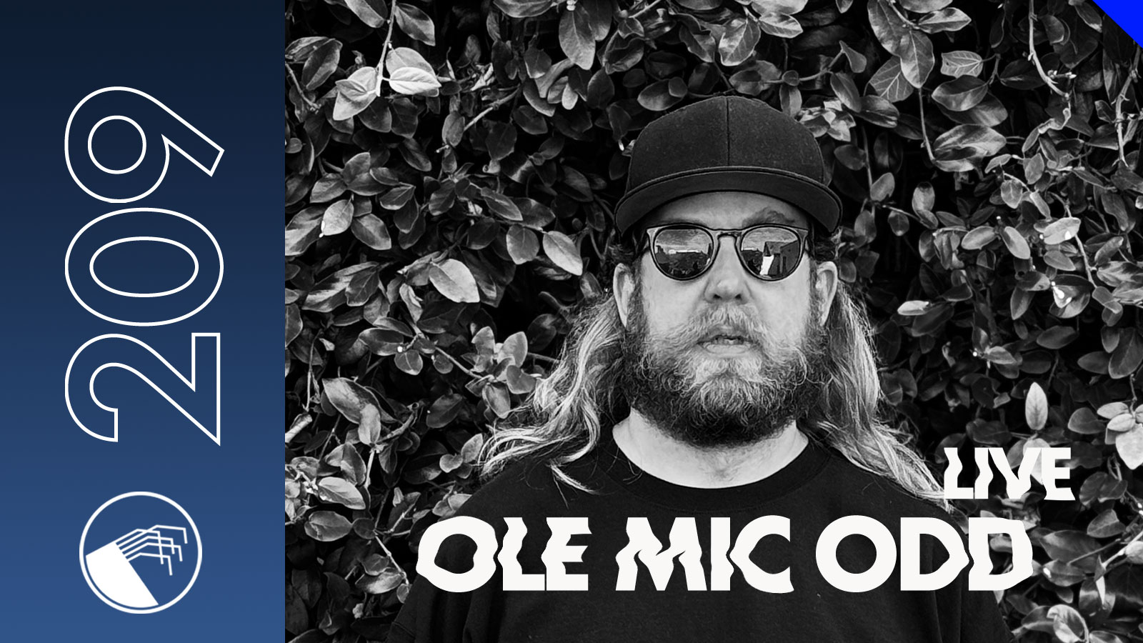 Ole Mic Odd in a black-and-white portrait outdoors, wearing sunglasses and a cap.